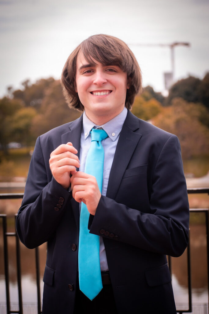 Liam Shotwell poses for the camera with a light blue tie.